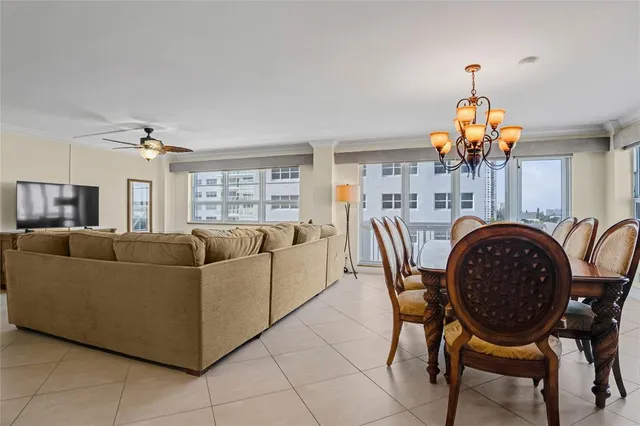 a living room with furniture a chandelier and a dining table