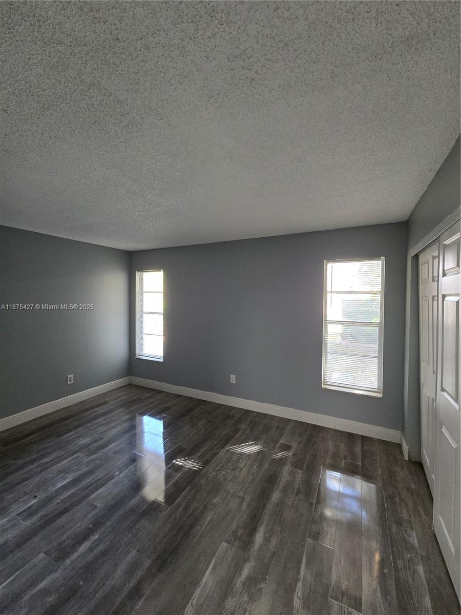 2800 Northwest 56th Avenue, Unit C104 Lauderhill, FL 33313 - Photo 12 of 17 an empty room with wooden floor and windows