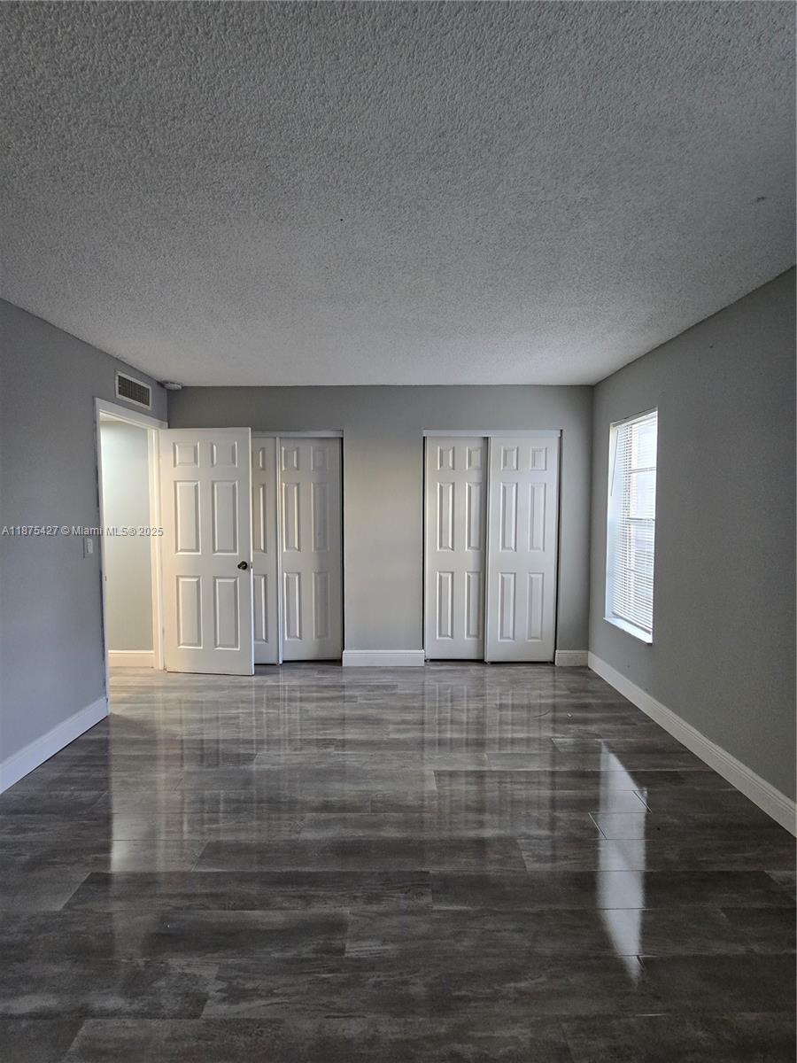 2800 Northwest 56th Avenue, Unit C104 Lauderhill, FL 33313 - Photo 15 of 17 a view of an empty room with window and wooden floor