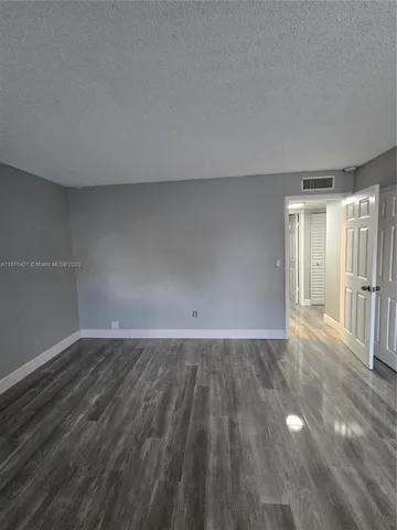 a view of an empty room and wooden floor