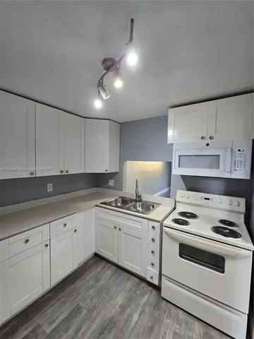 a kitchen with granite countertop cabinets stainless steel appliances and sink