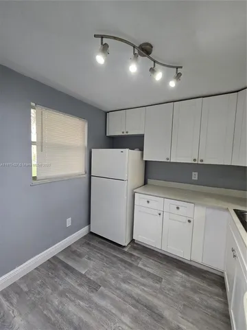 a kitchen with granite countertop cabinets and white appliances