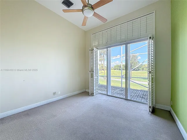 an empty room with a window and a fan