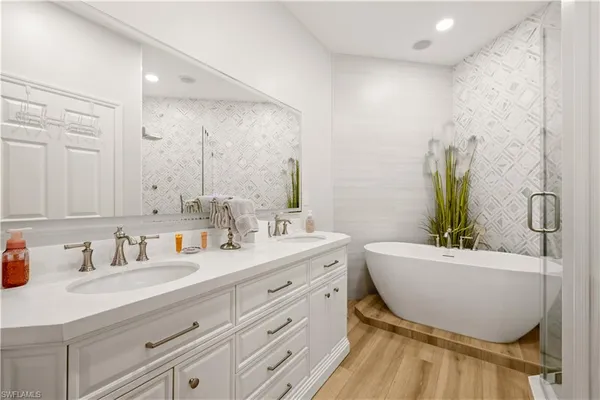 a bathroom with a bathtub sink and mirror