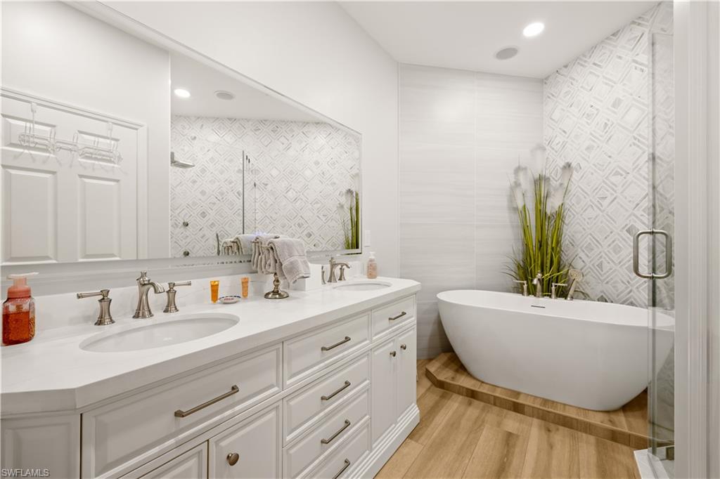 a bathroom with a bathtub sink and mirror