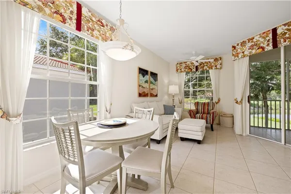 a dining room with furniture and large windows