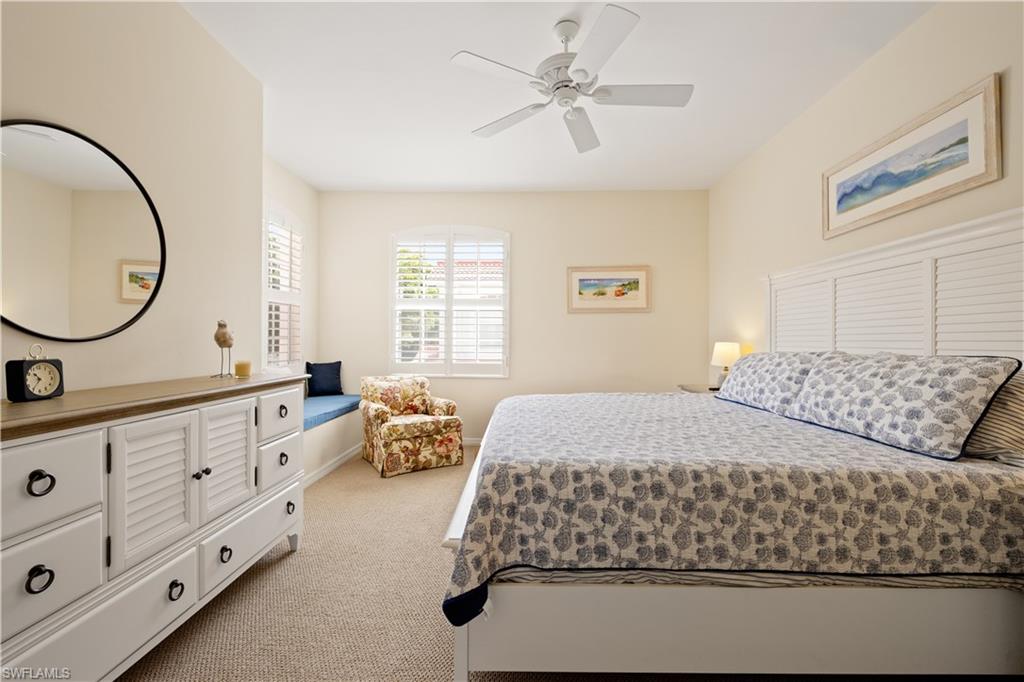 2180 Arielle Drive, Unit 810 Naples, FL 34109 - Photo 16 of 25 a bedroom with a large bed and a chandelier