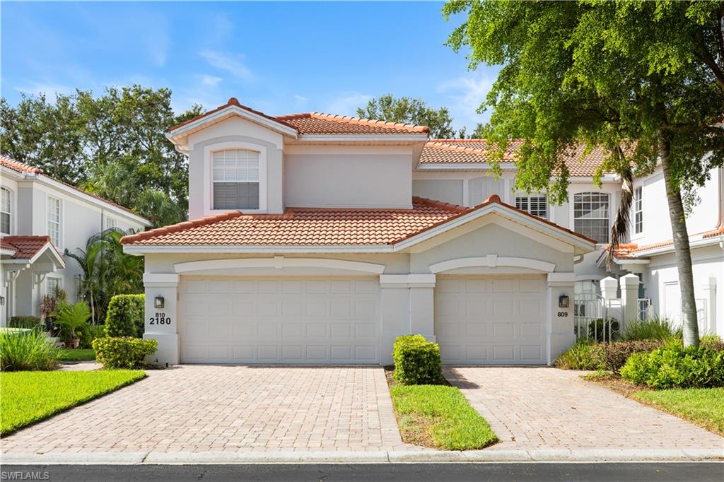 2180 Arielle Drive, Unit 810 Naples, FL 34109 - Photo 25 of 25 a view of a white house with a small yard and a large tree