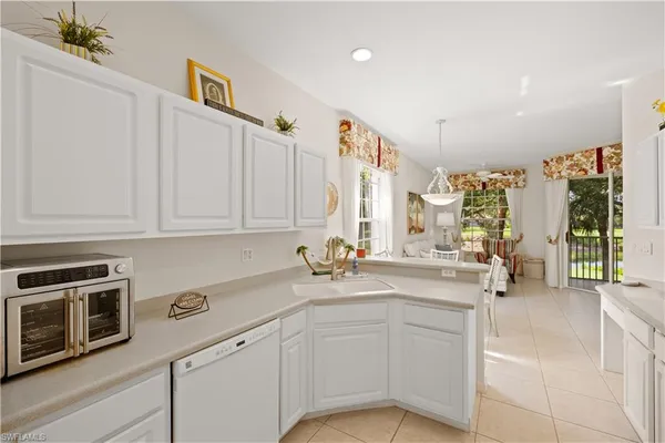 a kitchen with white cabinets and appliances