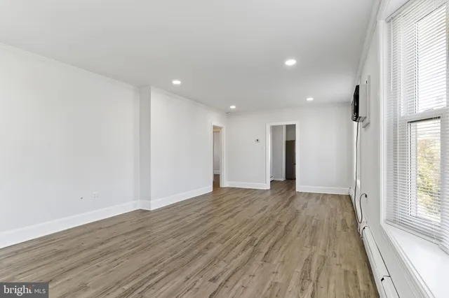 a kitchen with granite countertop a sink cabinets wooden floor and stainless steel appliances