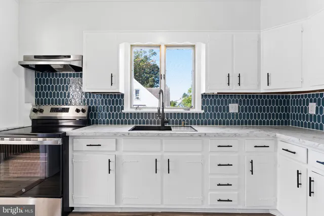 a kitchen with granite countertop white cabinets and black appliances