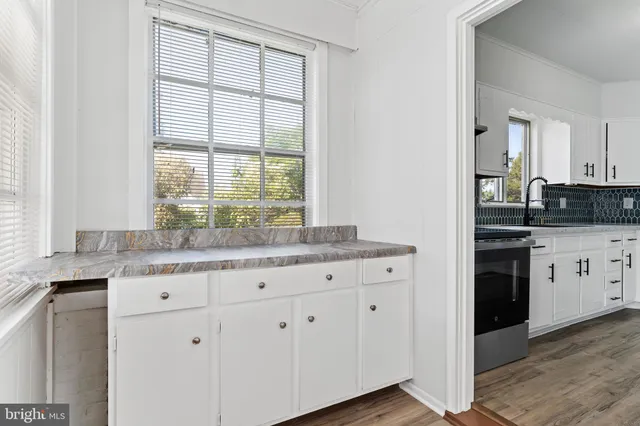 a kitchen with granite countertop a sink and a stove top oven