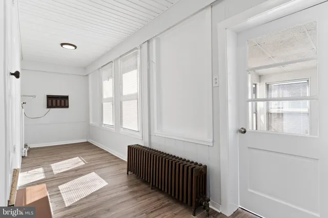 a view of a hallway with a bedroom and windows