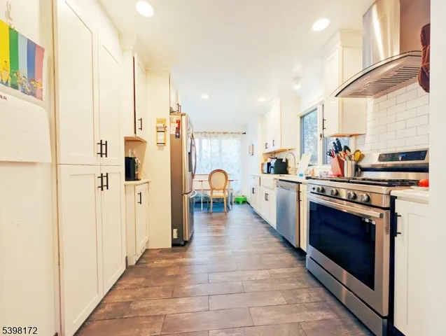 a kitchen with stainless steel appliances granite countertop a refrigerator and a stove
