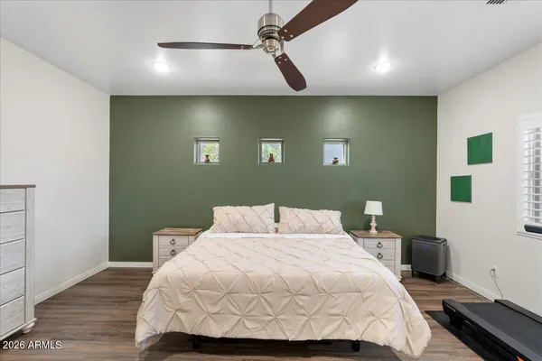a bedroom with a bed and a lamp on dresser