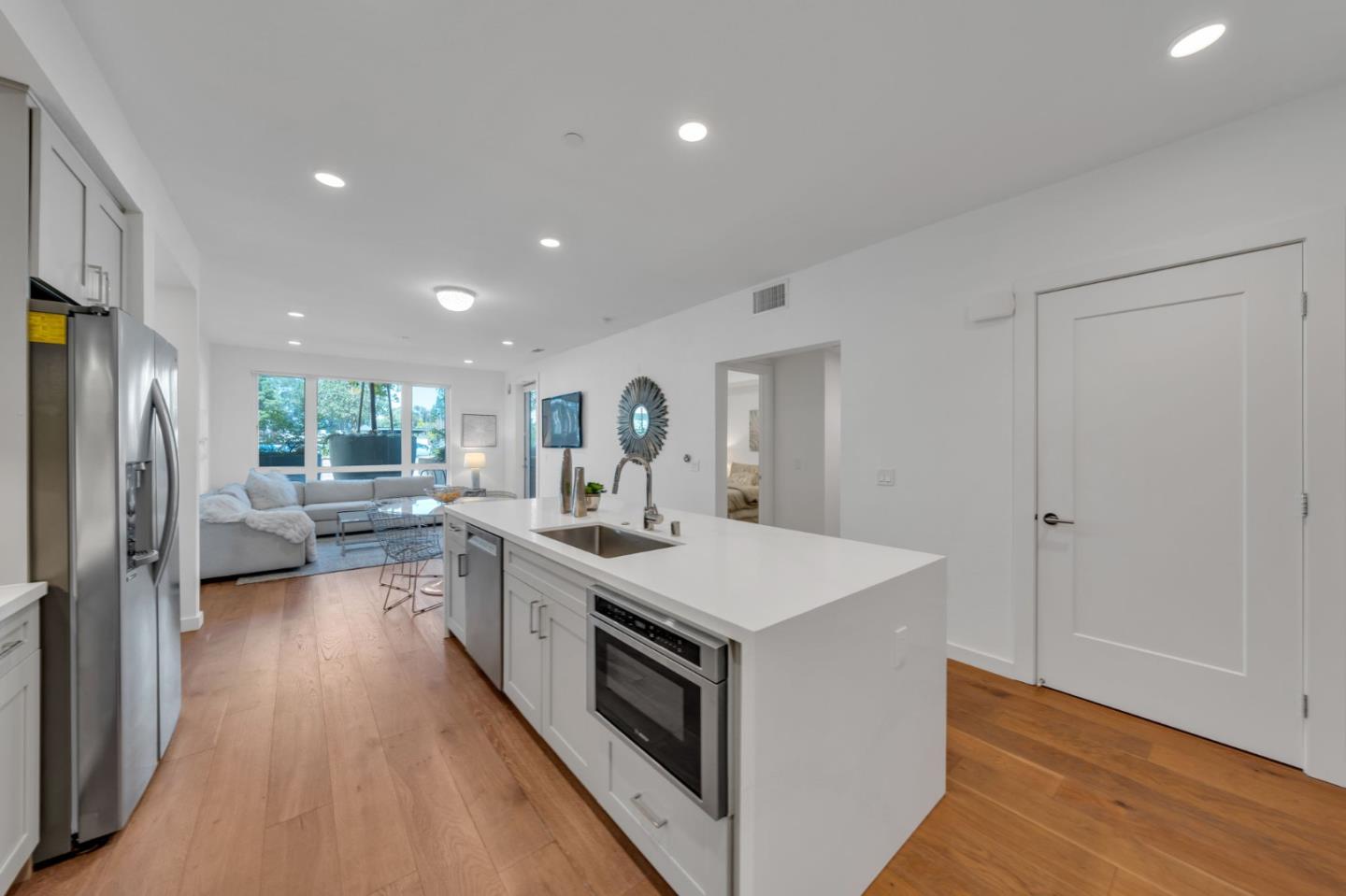 400 El Camino Real, Unit 117 Belmont, CA 94002 - Photo 1 of 54 a large kitchen with a large counter top a sink stainless steel appliances and cabinets
