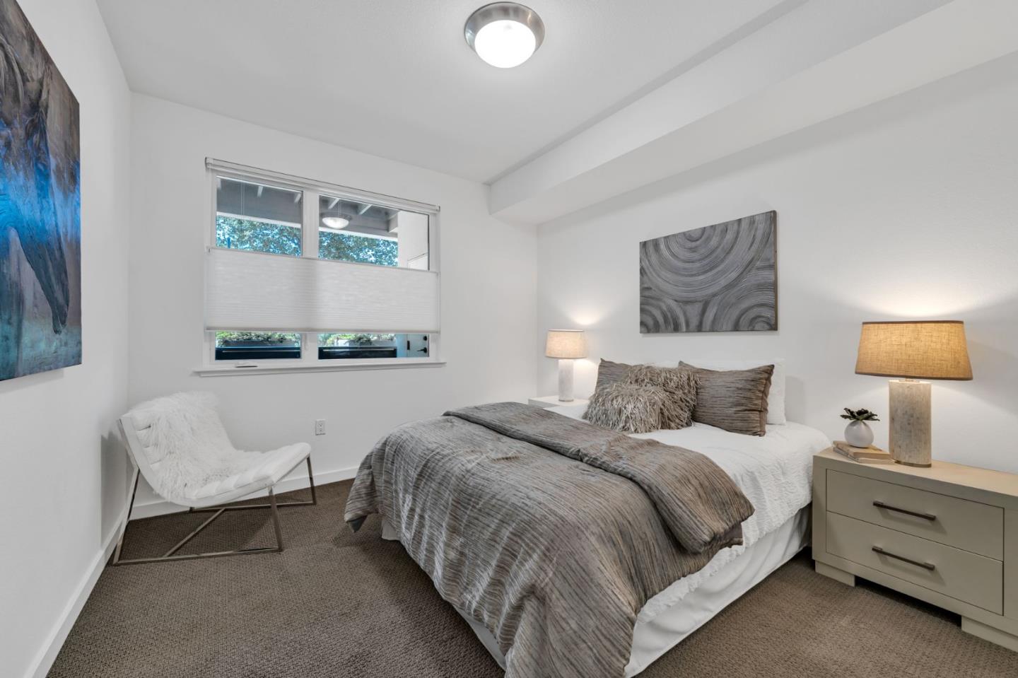 400 El Camino Real, Unit 117 Belmont, CA 94002 - Photo 20 of 54 a bedroom with a bed and a lamp