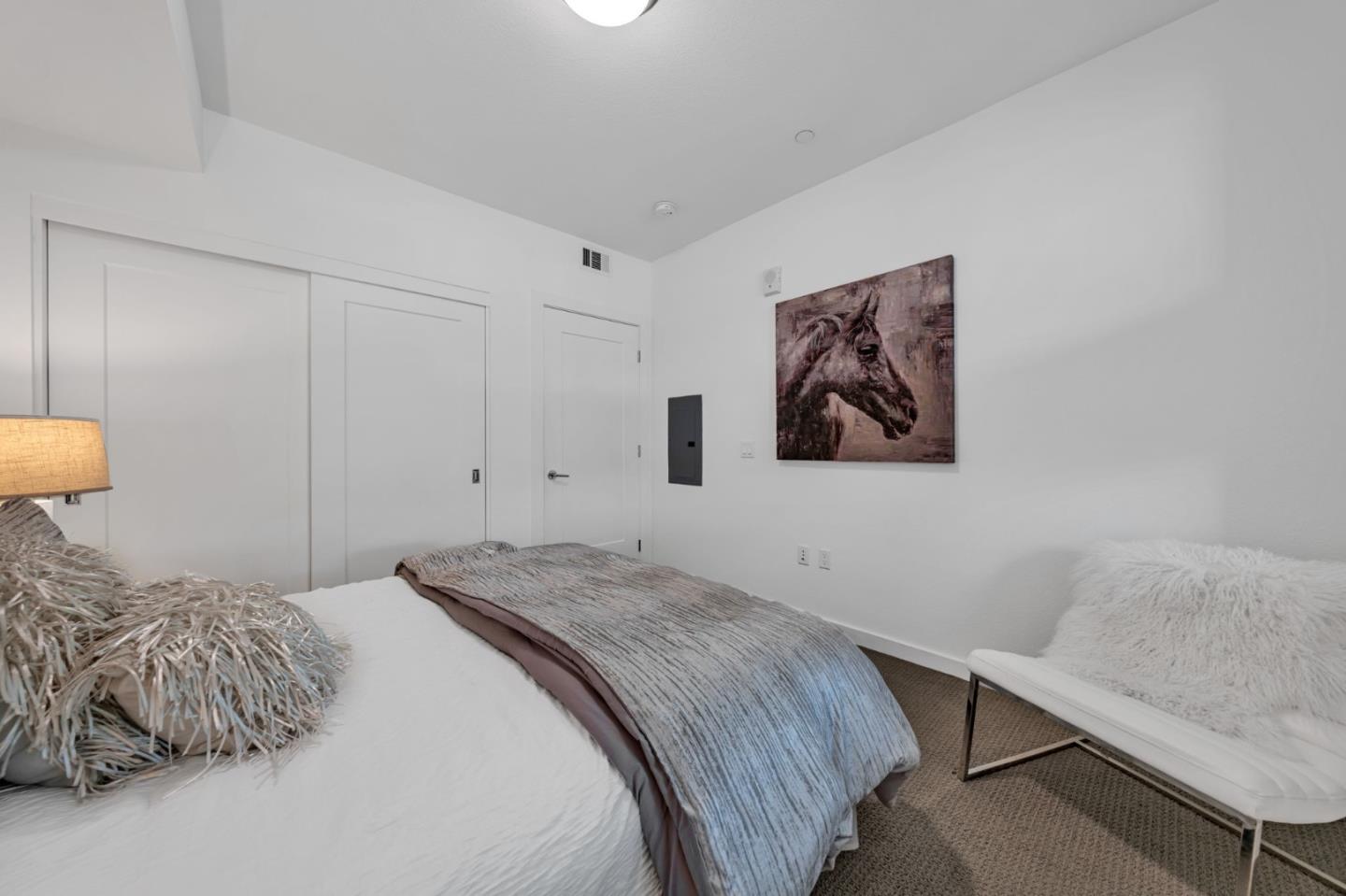 400 El Camino Real, Unit 117 Belmont, CA 94002 - Photo 21 of 54 a bedroom with a bed and a lamp on the dresser