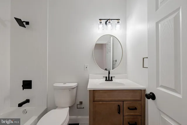 a bathroom with a toilet a sink and mirror