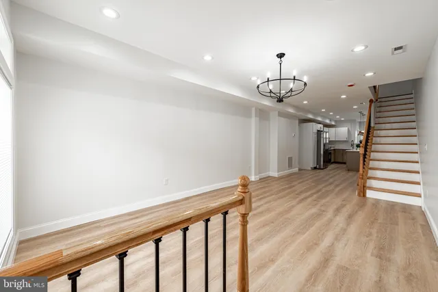 a view of a hallway with stairs and wooden floor