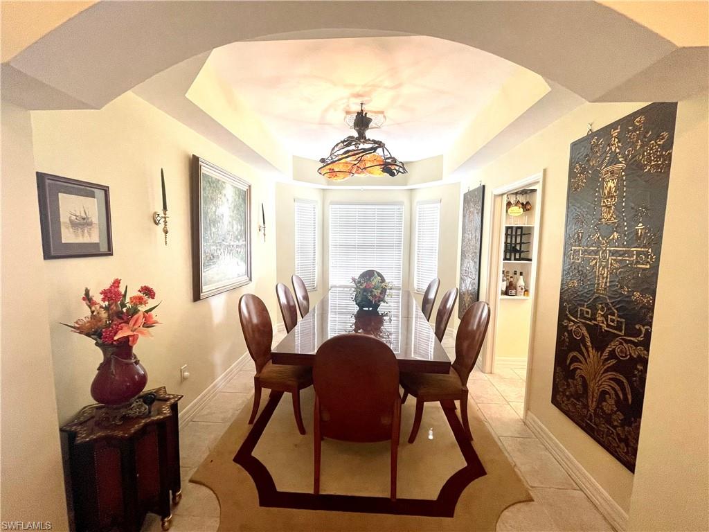 451 Bayfront Place, Unit 5311 Naples, FL 34102 - Photo 22 of 38 a dining room with furniture a chandelier and wooden floor