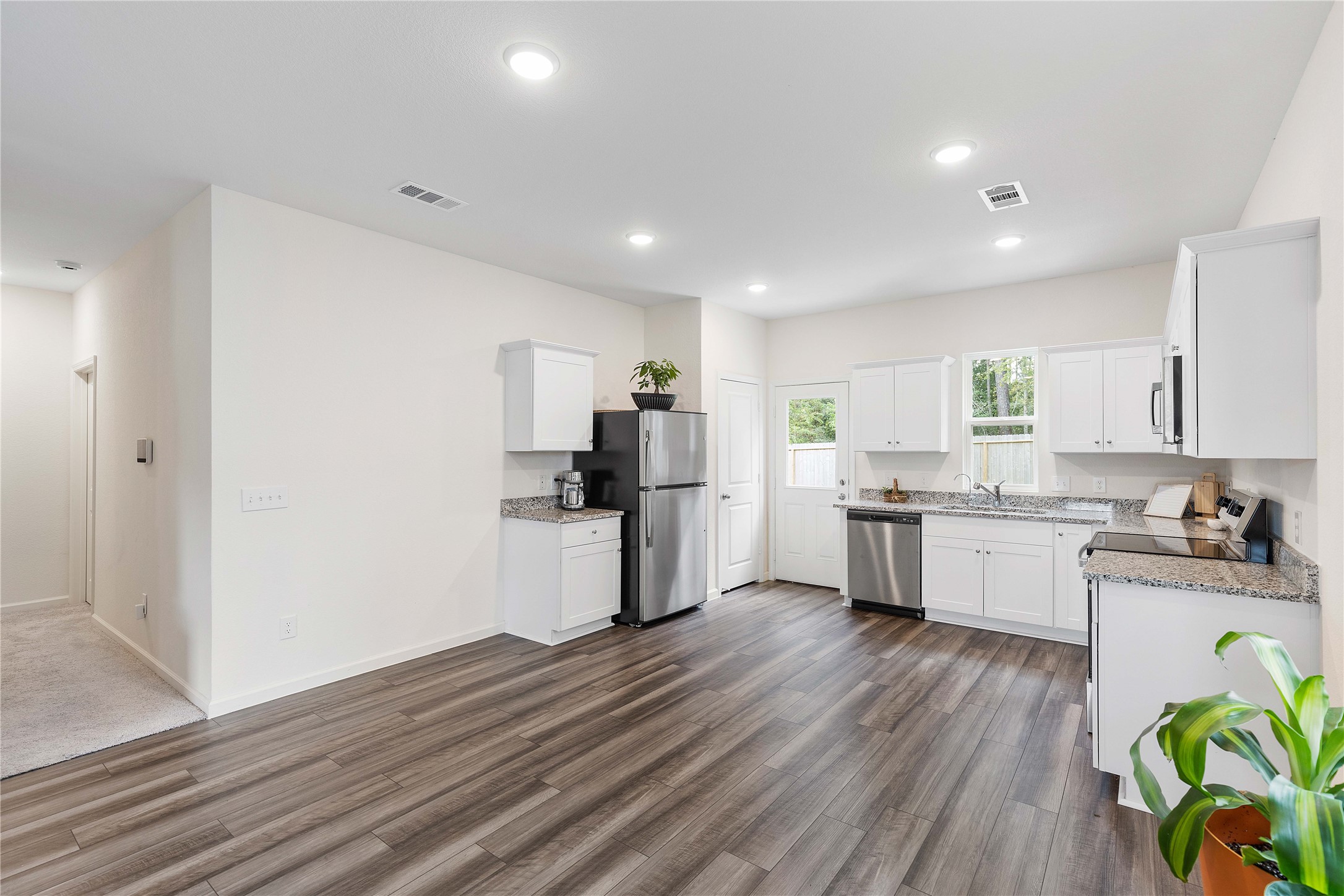 3626 Addington Ct. Huffman, TX 77336 - Photo 10 of 26 a kitchen with a white cabinets wooden floor and stainless steel appliances
