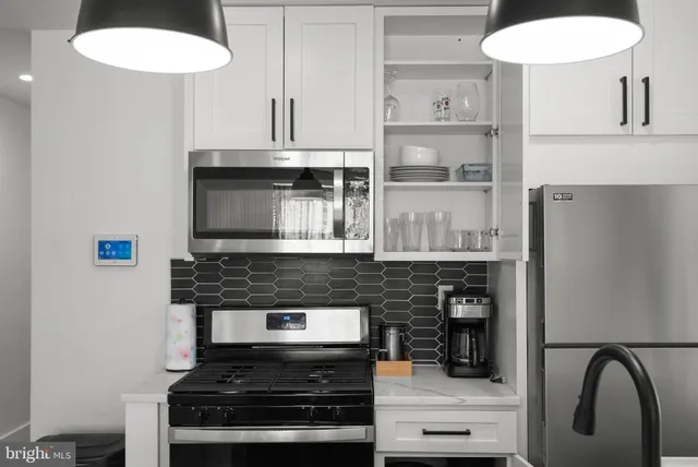 a kitchen with stainless steel appliances granite countertop a stove and a microwave