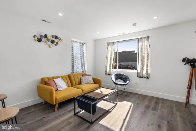 a living room with furniture a rug and a window