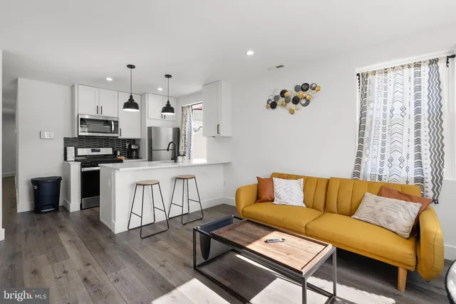 a living room with furniture and kitchen view