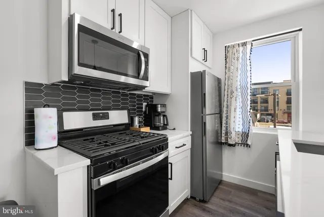 a kitchen with stainless steel appliances kitchen island a stove and a microwave