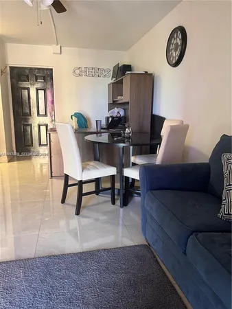 a living room with furniture a rug and a wall painting