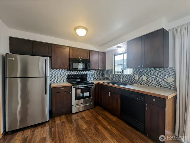 a kitchen with stainless steel appliances granite countertop a refrigerator stove a sink and dishwasher