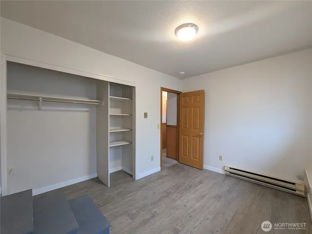 an empty room with a closet and windows