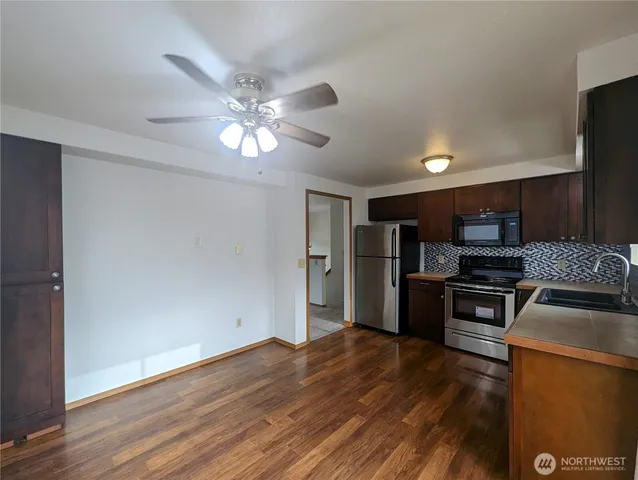 a kitchen with granite countertop stainless steel appliances and wooden floor