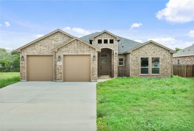 a front view of a house with a yard and garage