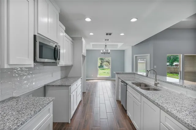 a kitchen with stainless steel appliances granite countertop a sink stove and refrigerator