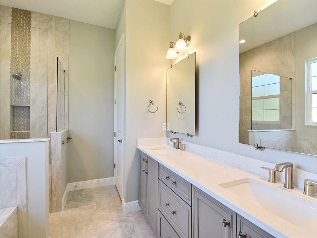 1891 East Cayman Road Vero Beach, FL 32963 - Photo 16 of 27 a bathroom with a double vanity sink and a mirror