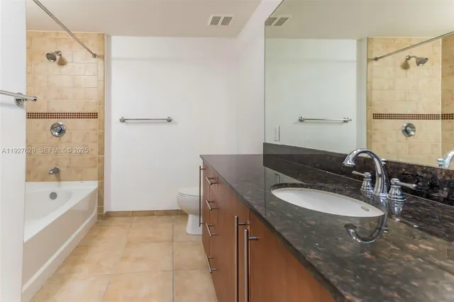 a bathroom with a granite countertop sink a mirror and a bathtub