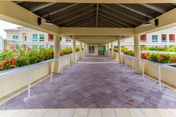 a view of a white building with a yard