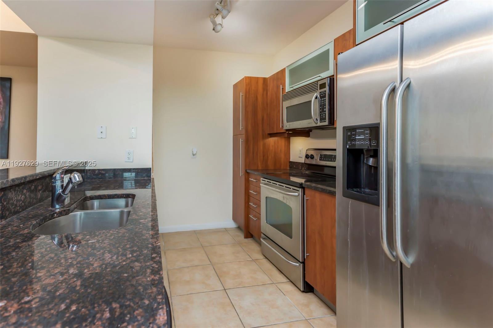 7355 Southwest 89th Street, Unit 721N Miami, FL 33156 - Photo 3 of 29 a kitchen with stainless steel appliances granite countertop a refrigerator and a sink
