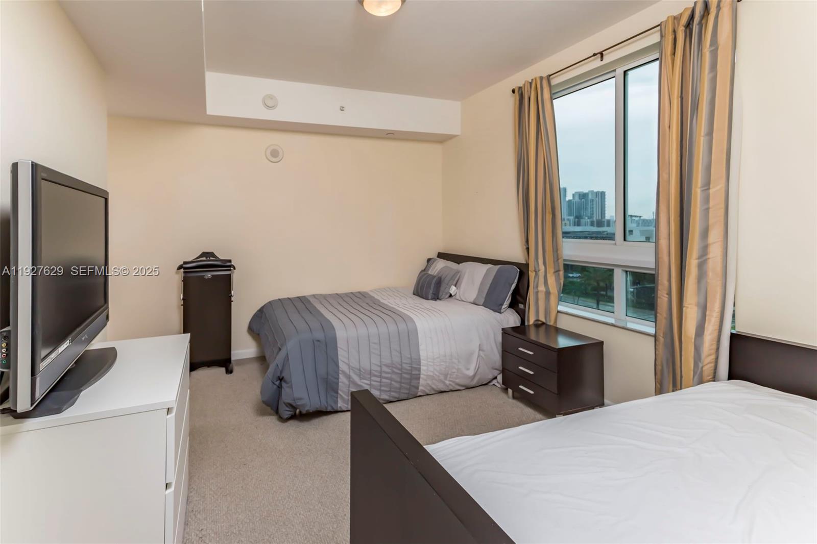 7355 Southwest 89th Street, Unit 721N Miami, FL 33156 - Photo 9 of 29 a bedroom with a bed and a flat tv screen on the dresser