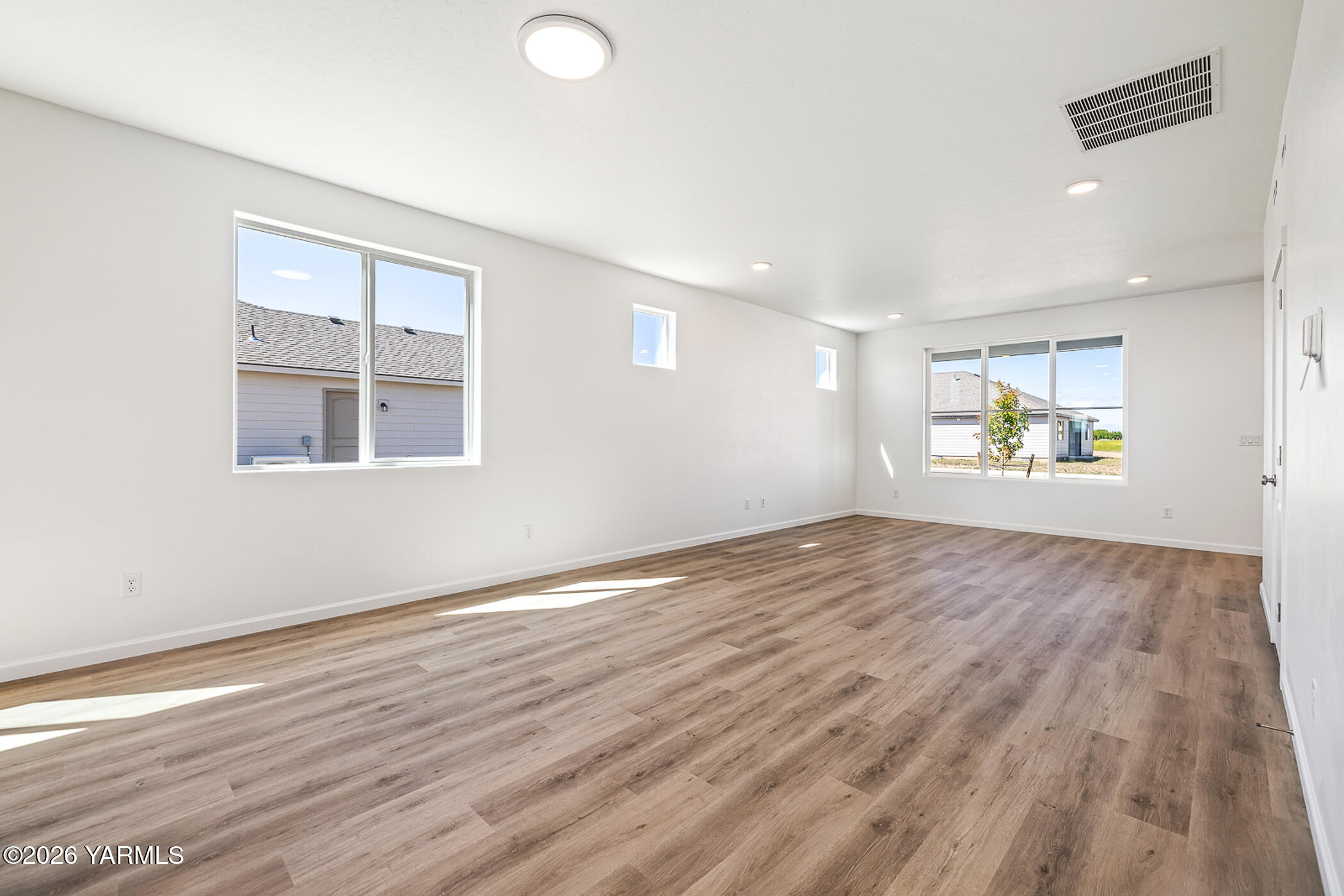 1603 Diamond Avenue Grandview, WA 98930 - Photo 4 of 32 an empty room with wooden floor and windows