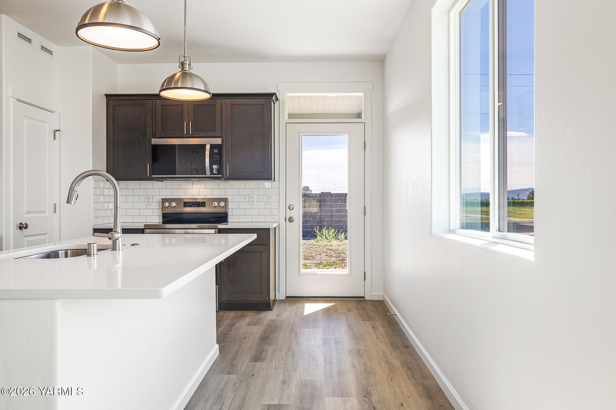 1603 Diamond Avenue Grandview, WA 98930 - Photo 10 of 32 a kitchen with kitchen island granite countertop a sink stainless steel appliances and counter space
