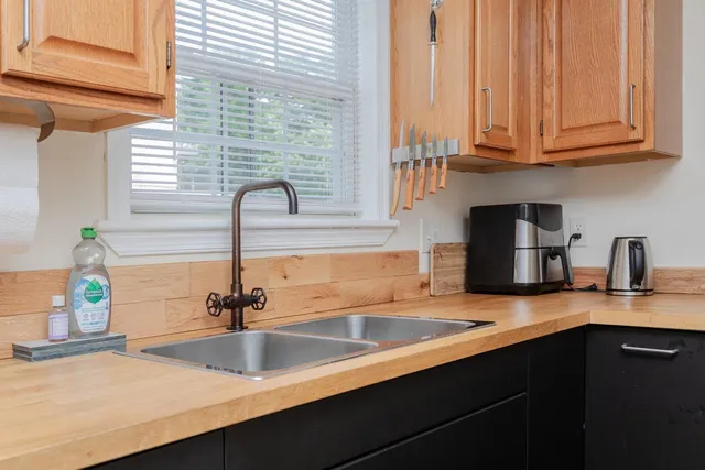 a kitchen with granite countertop a sink and a wooden cabinets