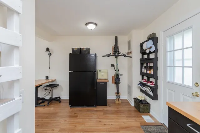 a kitchen with a refrigerator and a wooden floor