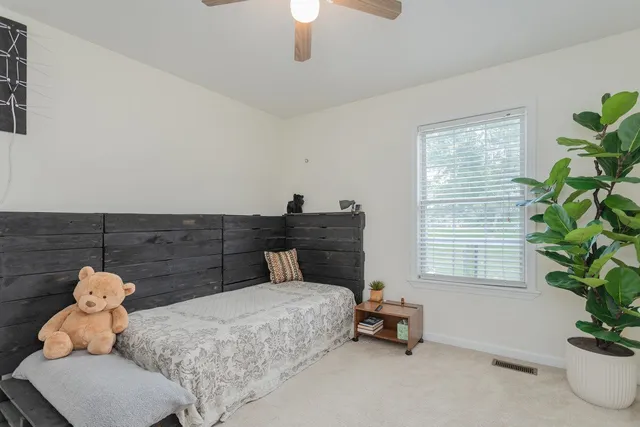 a bedroom with a bed and a potted plant