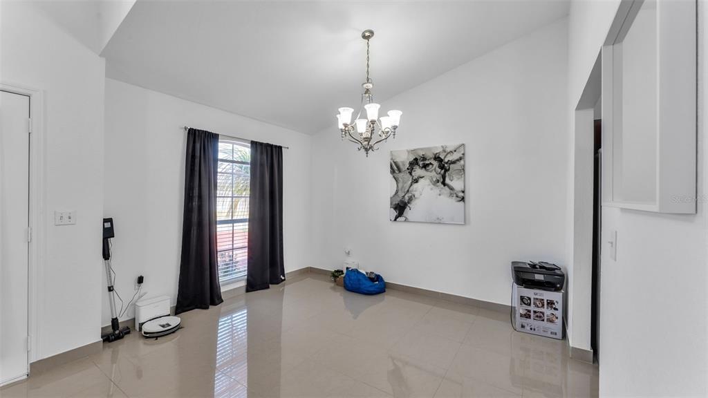 587 Drayton Road Winter Haven, FL 33884 - Photo 12 of 40 a bedroom with a bed and a chandelier