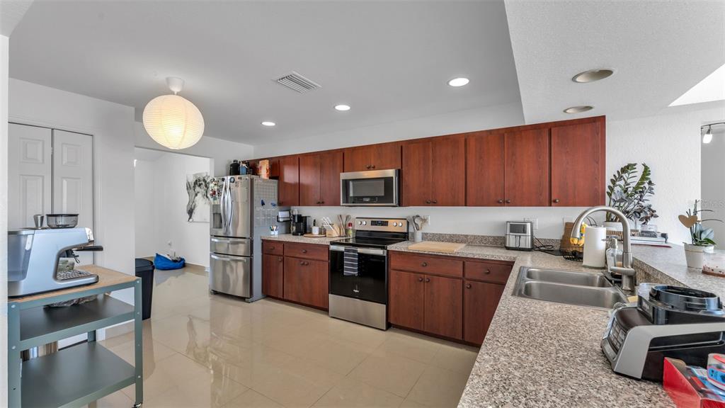 587 Drayton Road Winter Haven, FL 33884 - Photo 13 of 40 a kitchen with sink refrigerator and stove top oven