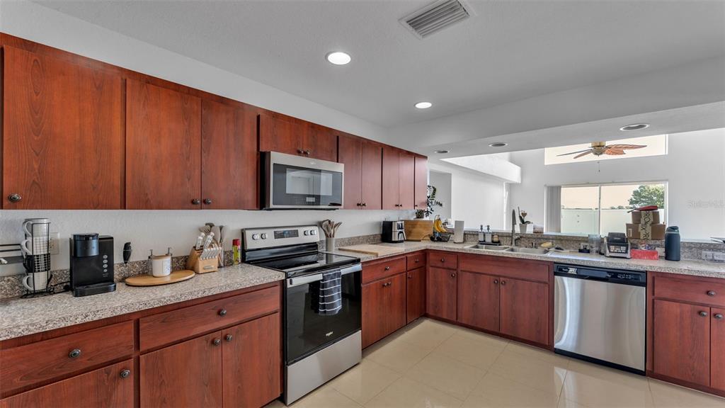 587 Drayton Road Winter Haven, FL 33884 - Photo 14 of 40 a kitchen with stainless steel appliances granite countertop wooden cabinets and sink
