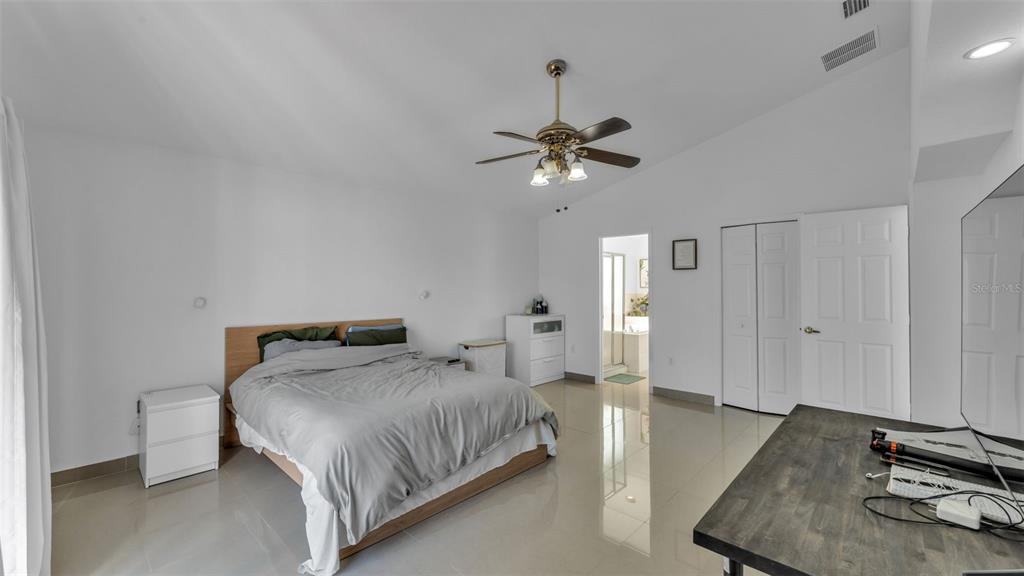 587 Drayton Road Winter Haven, FL 33884 - Photo 26 of 40 a bedroom with a bed and a chandelier